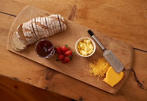 The perfect lunch. A view of a fresh bread, cheese and jam waiting to be eaten.