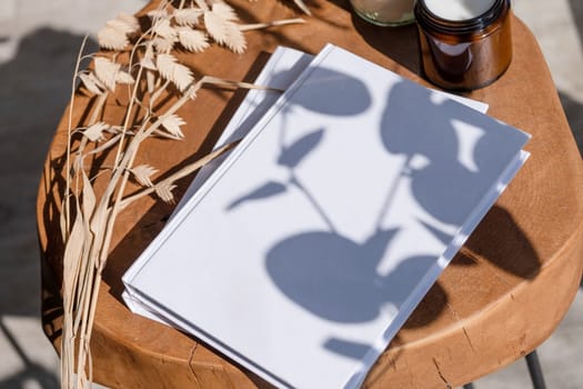 Magazine and book mockup design. Blank magazine on modern wooden table with candles , shadow overlay