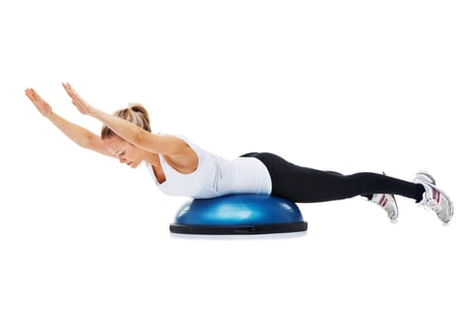 Working towards a perfectly toned body. A young woman working out using a bosu-ball.