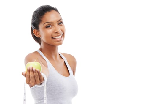 Choose the healthy alternative. A pretty young woman offering you an apple and a measuring tape while isolated on a white background.
