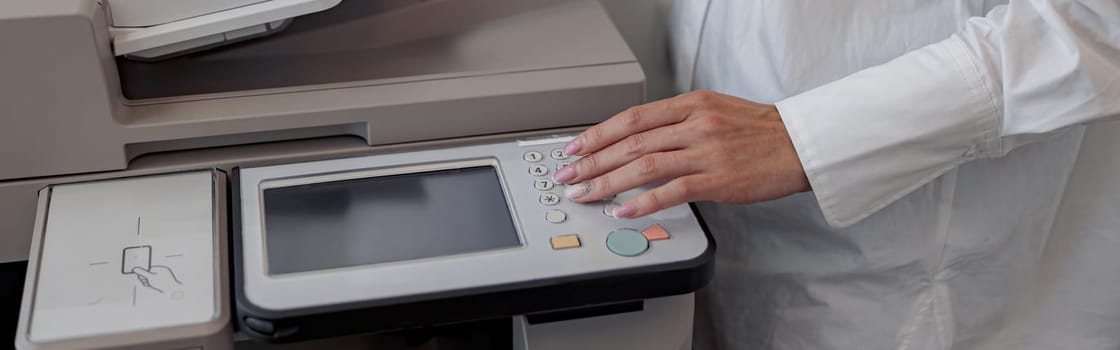 Close up of woman worker scanning a document on photocopy machine In modern office