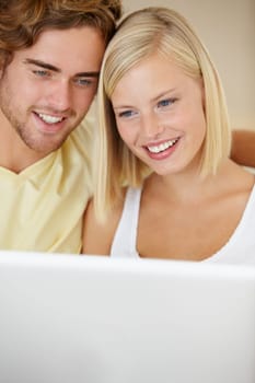 Video chatting with loved ones. A happy young couple video chatting online with friends and family