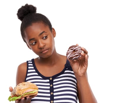 Trying to make the healthy choice. a young african american girl trying to choose between eating a donut or a sandwich.