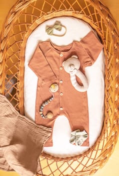 Baby clothes and accessories in basket bassinet.