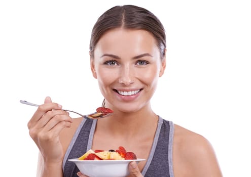 She loves living the healthy way. Portrait of an attractive young woman eating a bowl of fruit salad.