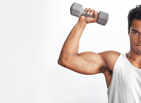Focus on fitness. A fitness shot of a muscular young man lifting a dumbbell.