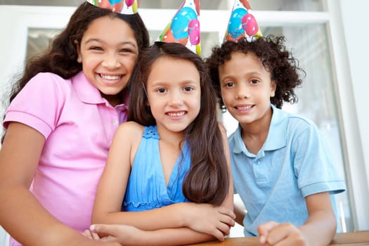 Celebrating a friends birthday. Portrait of three young children at a birthday party