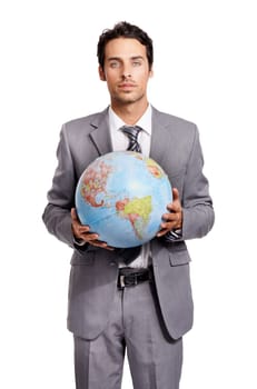 The world is yours if you work hard. A handsome young executive holding a globe while isolated on a white background.