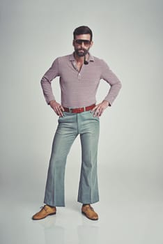 Respect my Authoritah. Studio shot of a handsome man striking a pose while wearing retro 70s style clothing.