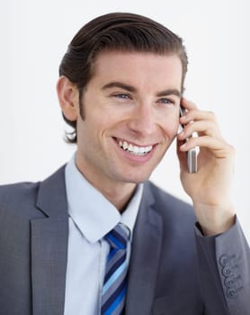 Networking is his speciality. A smiling young businessman talking on his smartphone.
