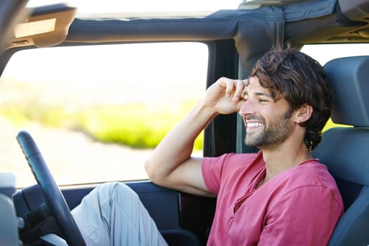 Carefree on the road. A young man enjoying his vacation road trip with a smile.