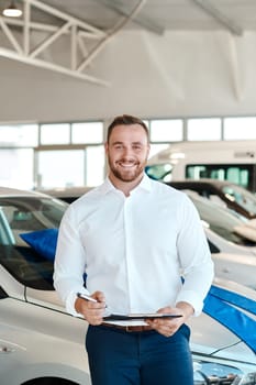 I have to maintain my flawless sales record. a car salesman holding a clipboard in his dealership.
