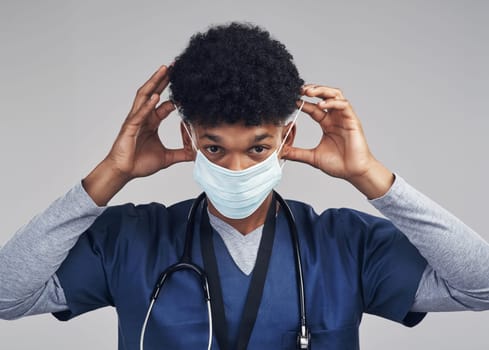 A healthier community is whats important to me, I hope its to you too. a male nurse wearing a surgical mask while standing against a grey background.