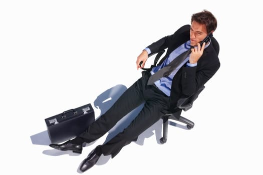 Top view of a relaxed business man using cell while on chair. Top view of a relaxed young business man sitting isolated on a chair and talking on the cellphone.