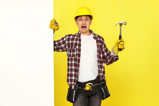 professional builder in work clothes in helmet holding hammer.