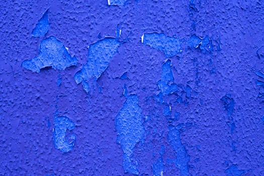 Old weather damaged blue paint on the wall.