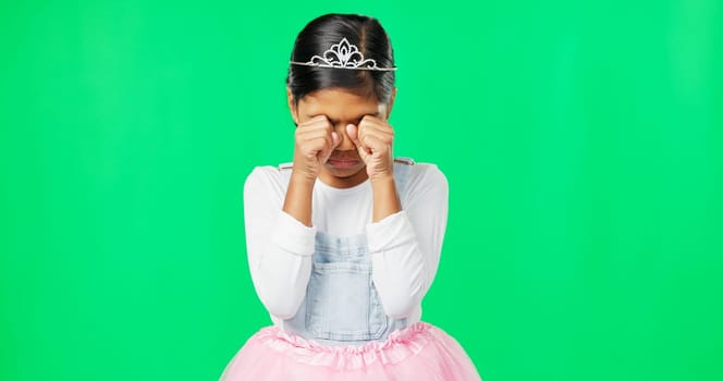 Sad, depression and child crying on green screen with crown, princess costume and tutu in studio. Sadness mockup, tears and isolated young girl with worried, upset and disappointed facial expression