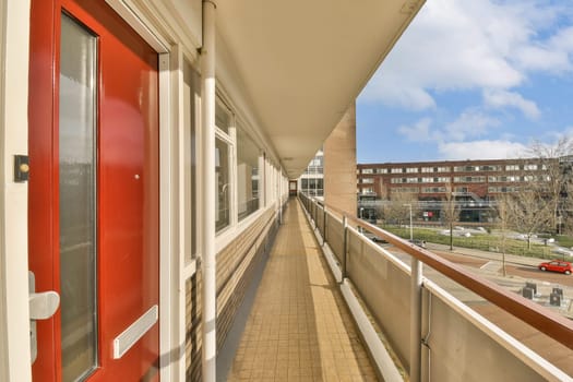 the corridor of a building with a red door