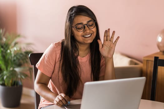 Happy indian woman freelancer or entrepreneur have video conference talking, working remotely online at home office - video call and diversity concept