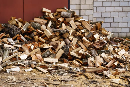 Dry chopped firewood in a pile near the wall