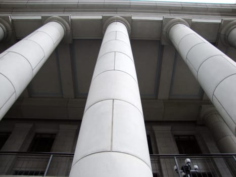 A stately white building with three pillars is a landmark in the city