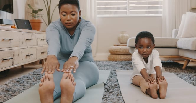 Shot of a young mother and daughter doing yoga at home