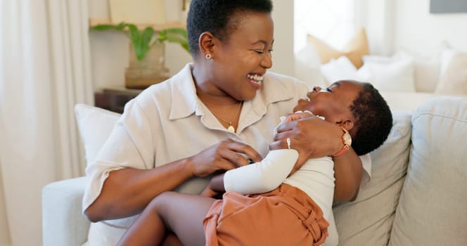 Mother, family and child at home with a black woman having fun, love and laugh for tickle and playing on living room sofa. Bonding mom and girl smile, happy and play together on couch house in home