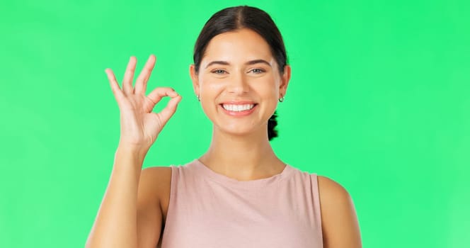 Face, green screen and woman with ok sign, perfect and happiness against a studio background. Portrait, female and happy person with hand gesture for approval, symbol for agreement and satisfaction