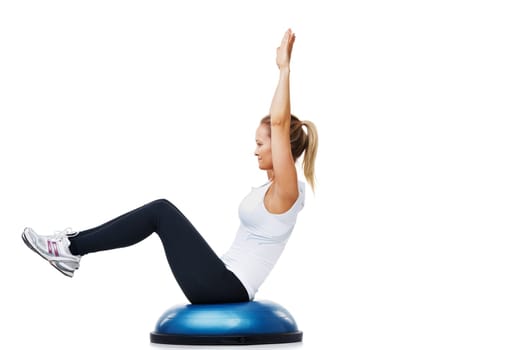 Reaching towards a higher level of fitness. A young woman balancing on a bosu-ball.