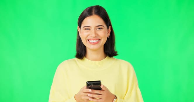 Smile, woman and smartphone on green screen, face and studio for social media, online contact and meme. Portrait of happy female model typing on cellphone, download mobile games or scroll for texting