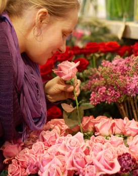 Woman, smelling roses and retail for floral bouquet for scent, color and shopping for valentines day gift. Flowers, leaves and sustainable plants for beauty, present and sale in startup florist store