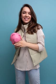 young brunette woman decides where to invest her savings from the piggy bank