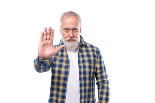 50s elderly gray-haired man with beard greets showing palm on white background