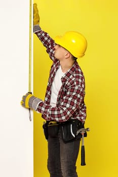 builder in work clothes, helmet taking measurements of wall
