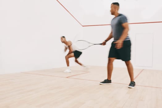 The more you practice the better you become. two young men playing a game of squash.
