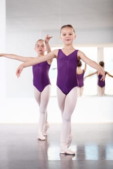 Young and graceful. Two young girls dancing in a ballet studio.