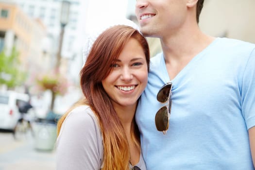Enjoying the City life in Summer. Portrait of a beautiful girl being embraced by her boyfriend on a city street.