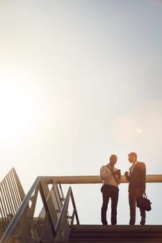 Networking is important in business. Low angle shot of two businessmen talking on top of stairs outside.
