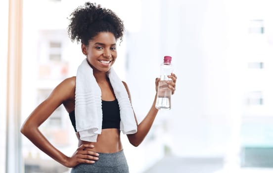 We all need exercise and water. a beautiful young woman holding up a bottle of water.