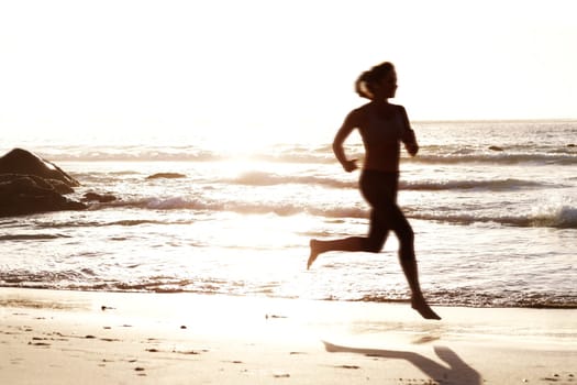 Young female running on beach during sunset. Portrait of a young female running on the sea shore at sunset.
