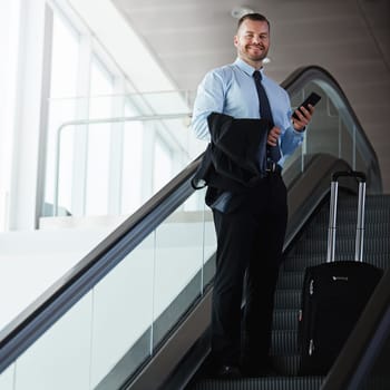Making business travel an enjoyable experience. a businessman traveling down an escalator in an airport