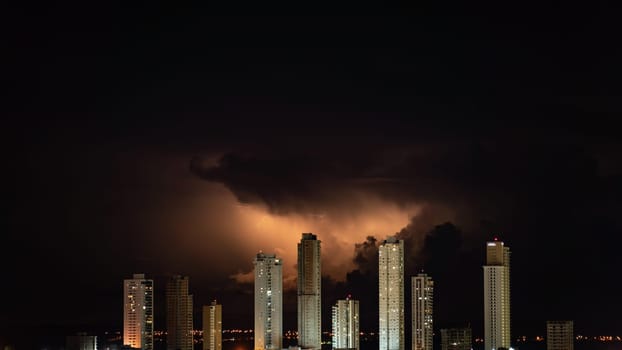 Electric storm over city skyscrapers in the dark night sky