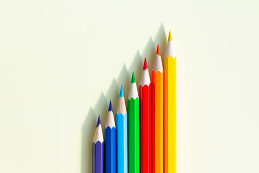 A large number of sharpened colored pencils with falling shadow from natural light on a bright sunny day.