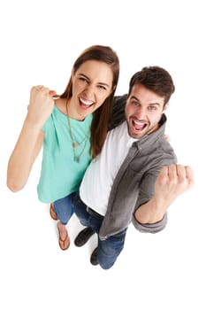 Were a winning combination. High-angle shot of a happy young couple in studio raising their fists in victory.