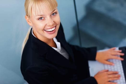 Female executive with laptop. Business woman smiling and working on laptop.