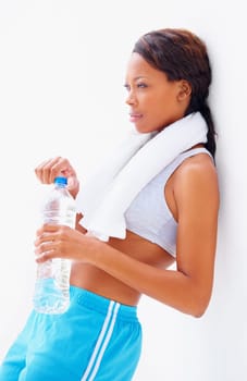 Relaxing after her exercise. Young african in gymwear with a towel around her neck while drinking some water.