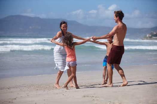 These are the memories that will last forever. a happy family being playful at the beach.