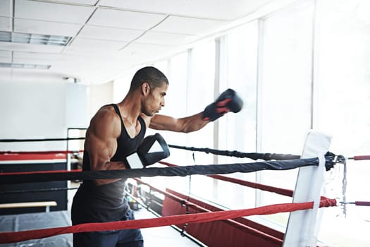 Nothing maximizes potential more than practice. a young man training in a boxing ring.
