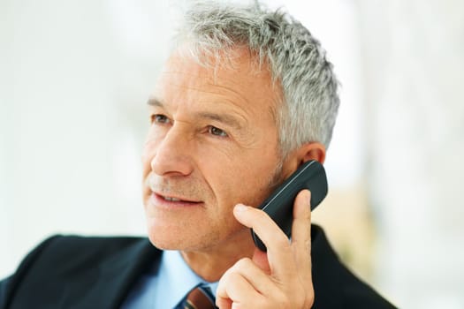 Hes a connected businessman. a mature businessman talking on a cellphone.