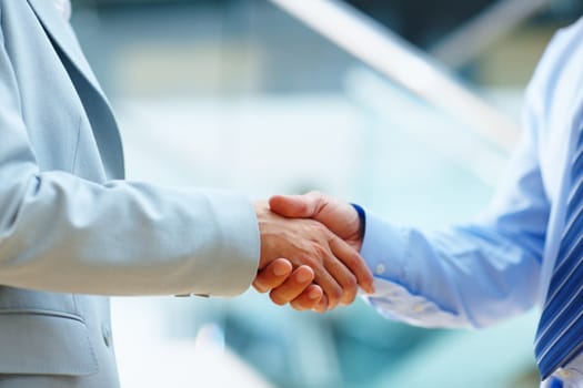Youve got yourself a deal. two people shaking hands in a corporate environment.